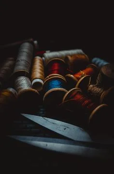 Retro sewing items: tailoring scissors, cutting knife, thimble, wooden thread Stock Photos