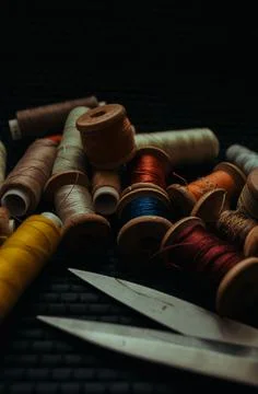 Retro sewing items: tailoring scissors, cutting knife, thimble, wooden thread Stock Photos