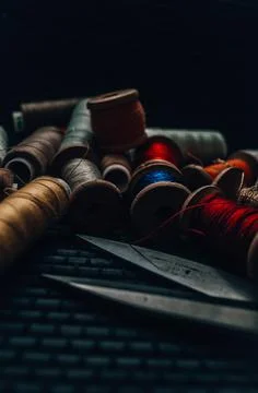 Retro sewing items: tailoring scissors, cutting knife, thimble, wooden thread Stock Photos