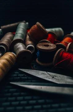 Retro sewing items: tailoring scissors, cutting knife, thimble, wooden thread Stock Photos