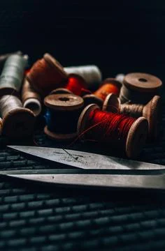 Retro sewing items: tailoring scissors, cutting knife, thimble, wooden thread Stock Photos