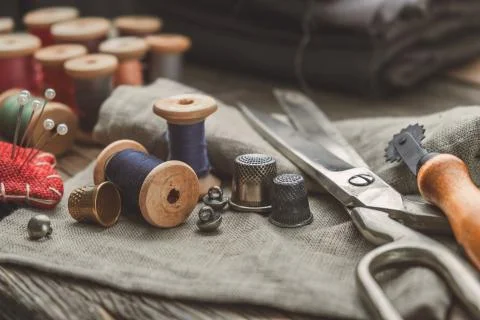 Retro sewing set: tailoring scissors, cutting knife, thimble, threads Stock Photos
