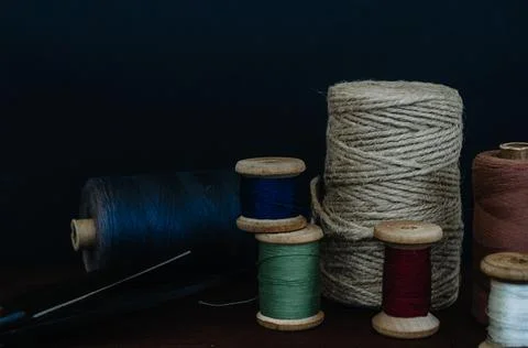 Retro sewing tools: old scissors, bobbins of thread on gray fabric. Tailor's  Stock Photos