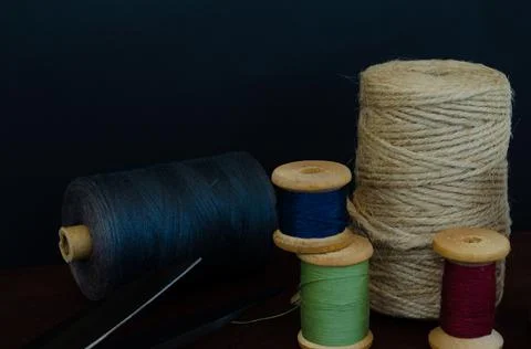 Retro sewing tools: old scissors, bobbins of thread on gray fabric. Tailor's  Stock Photos