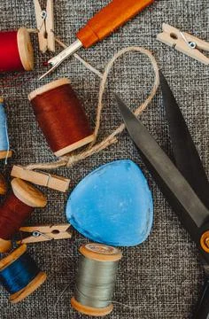 Retro sewing tools: old scissors, bobbins of thread on gray fabric. Tailor's  Stock Photos