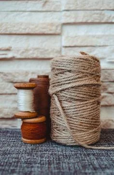 Retro sewing tools: old scissors, bobbins of thread on gray fabric. Tailor's  Stock Photos