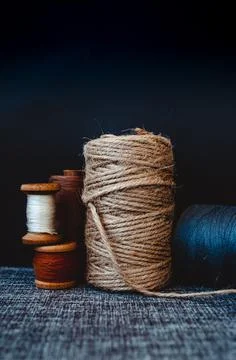 Retro sewing tools: old scissors, bobbins of thread on gray fabric. Tailor's  Stock Photos