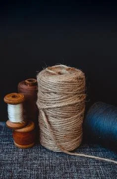 Retro sewing tools: old scissors, bobbins of thread on gray fabric. Tailor's  Stock Photos