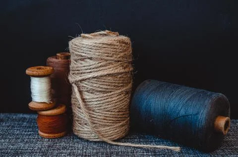 Retro sewing tools: old scissors, bobbins of thread on gray fabric. Tailor's  Stock Photos