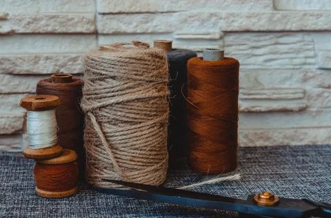 Retro sewing tools: old scissors, bobbins of thread on gray fabric. Tailor's  Stock Photos