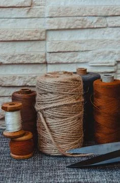Retro sewing tools: old scissors, bobbins of thread on gray fabric. Tailor's  Stock Photos