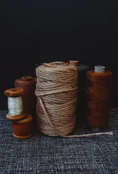 Retro sewing tools: old scissors, bobbins of thread on gray fabric. Tailor's  Stock Photos