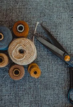 Retro sewing tools: old scissors, bobbins of thread on gray fabric. Tailor's  Stock Photos