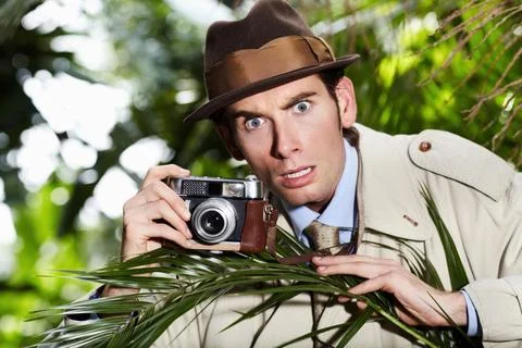 Retro spy man, camera and jungle for investigation, inspection or journalist Stock Photos