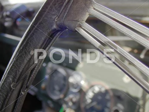 Retro steering wheel close up with out of focus gauges in a Land Rover Series II Stock Photos