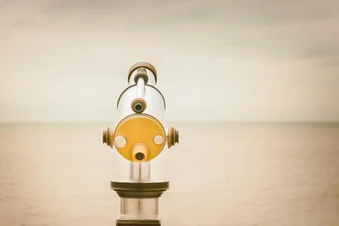 Retro styled image of a Dutch beach binocular viewer in front of the North Se Photos