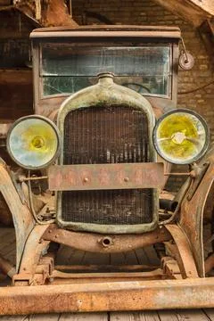 Retro styled image of an early twentieth century rusted and broken classic ca Foto stock