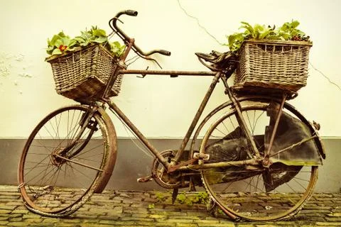 Retro styled image of an old bicycle with baskets Stock Photos