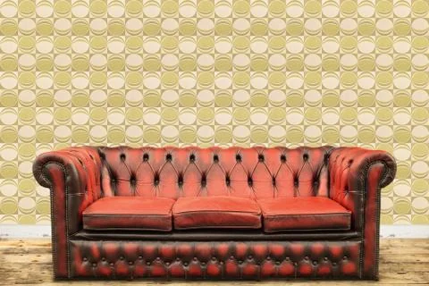 Retro styled image of an old sofa against a vintage wallpaper wall Stock Photos
