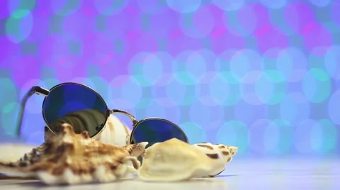 Retro sunglasses with shell and blurry shining colored background Stock Footage 46015376