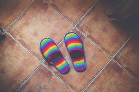Retro toned rainbow color pattern slippers on the floor Stock Photos