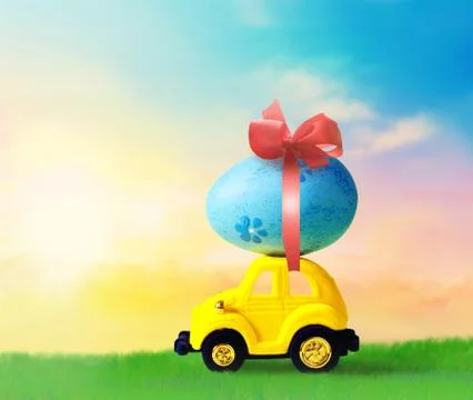 Retro toy car with Easter egg on the roof on spring background. Easter concep Stock Photos