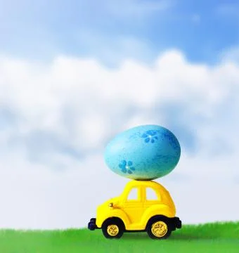 Retro toy car with Easter egg on the roof on spring background. Easter concep Foto stock