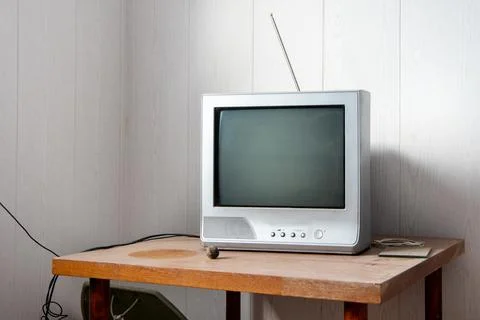 A retro TV with antennas stands on a dusty table. Angle view Stock Photos