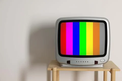 Retro TV set with test pattern on wooden table near white wall. Color bars .. 写真素材
