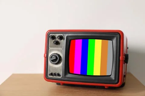 Retro TV set with test pattern on wooden table near white wall. Color bars .. 写真素材