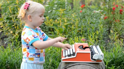 Retro Typewriter Machine in use. Little Girl Writer Printing in a Garden. Stockbeeldmateriaal 39417569