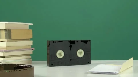 Retro VHS Tape and Stack of Books on White Table with Green Screen Background Vídeos de archivo 344678210
