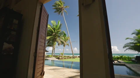 Retro villa living room exit to backyard with swimming pool and ocean shore Stock Footage 251619368