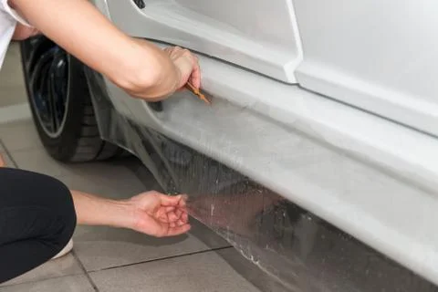 Retrofitting the car with a solid transparent protective film, the master glu Stock Photos
