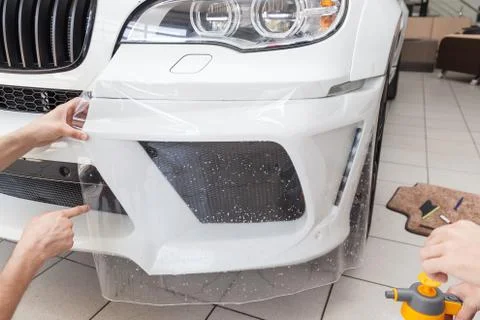 Retrofitting the car with a solid transparent protective film, the master glu Stock Photos