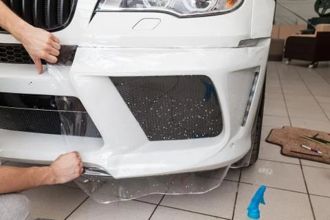 Retrofitting the car with a solid transparent protective film, the master glu Stock Photos