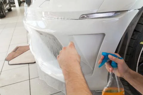 Retrofitting the car with a solid transparent protective film, the master glu Stock Photos