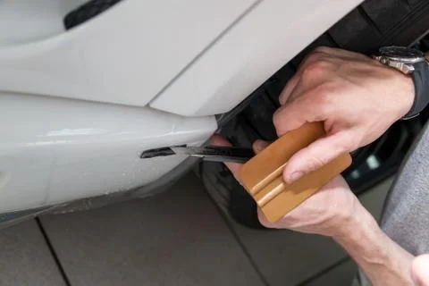 Retrofitting the car with a solid transparent protective film, the master mak Stock Photos