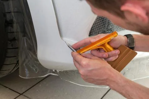 Retrofitting the car with a solid transparent protective film, the master mak Stock Photos