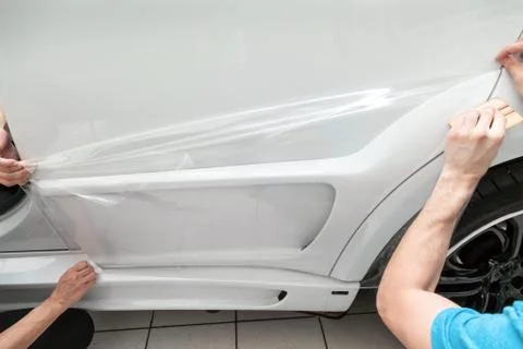 Retrofitting the car with a solid transparent protective film, the master pul Stock Photos