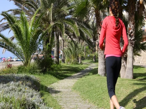 REUP backWomanRunningBetweenPalm Stock Footage 80892693