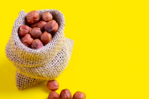 Reusable bag with hazelnuts on yellow background. Zero waste and plastic free Stock Photos