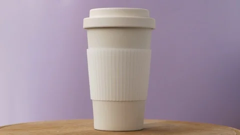 Reusable bamboo coffee cup rotating on the pink background Video stock 115367926