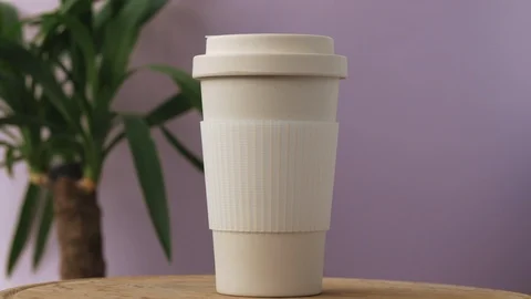 Reusable bamboo coffee cup rotating on the pink background Video stock 115367979