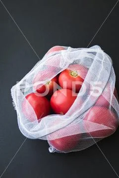 Reusable eco-friendly bag full of fresh seasonal tomatoes Stock Photos