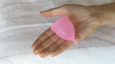Reusable menstrual cup placed on hand with soft background. Scene highlights Stock Footage 330459977