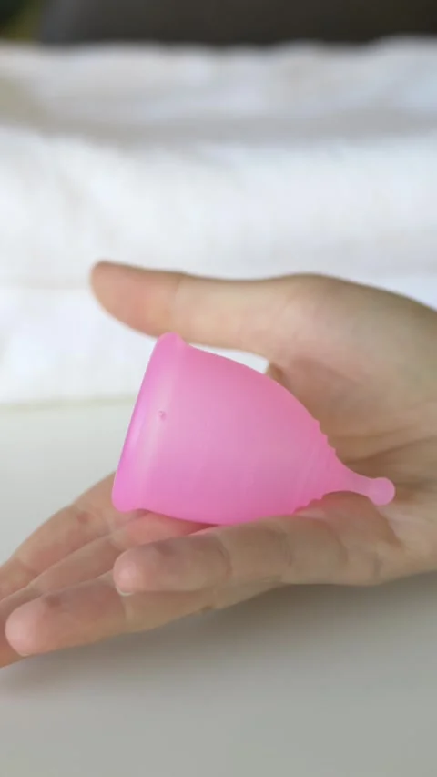 Reusable menstrual cup placed on hand with soft background. Scene highlights Stock Footage 330480725