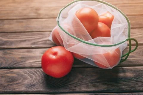 Reusable mesh bag with tomatoes. Stock Photos