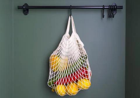 A reusable shopping string bag with vegetables and fruit from the supermarket Foto stock