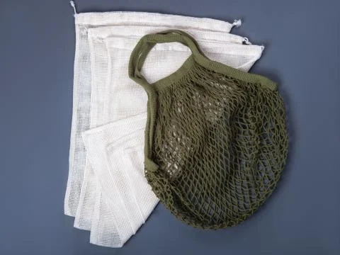 Reusable string bag and sacks for different products on the grey background. Stock Photos